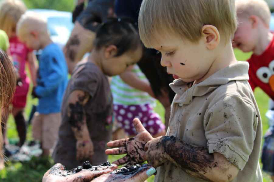 boys playing in mud with their hands
